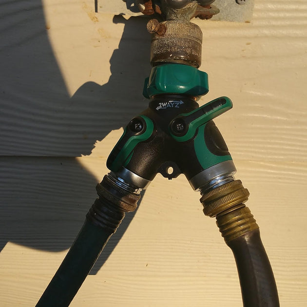 a green and black hose connected to a wall