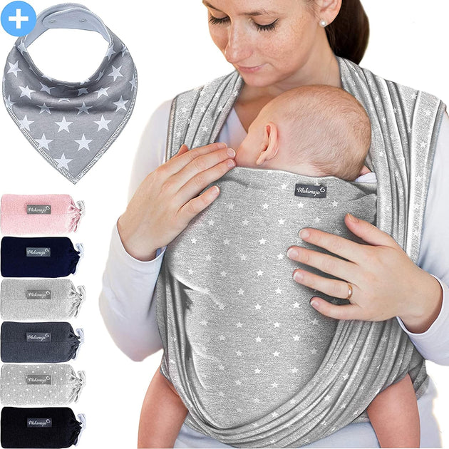 a woman holding a baby in a baby carrier